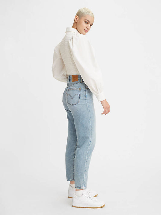 Woman is wearing Levi's high loose taper fit jeans. Jeans feature a flattering high rise, stacked, tapered leg and fitted with a relaxed silhouette. Jeans are paired with a white blouse. (7721824452816)