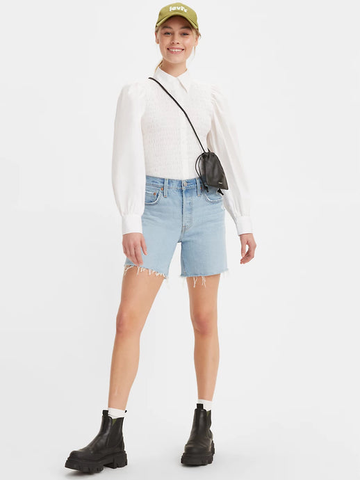 Women is wearing Levi's 501 original mid thigh shorts in light wash color. Jean shorts are styled witha white shirt and black boots. Jean shorts feature high waist, bermuda lenght and classic straight fit. (7721852010704)
