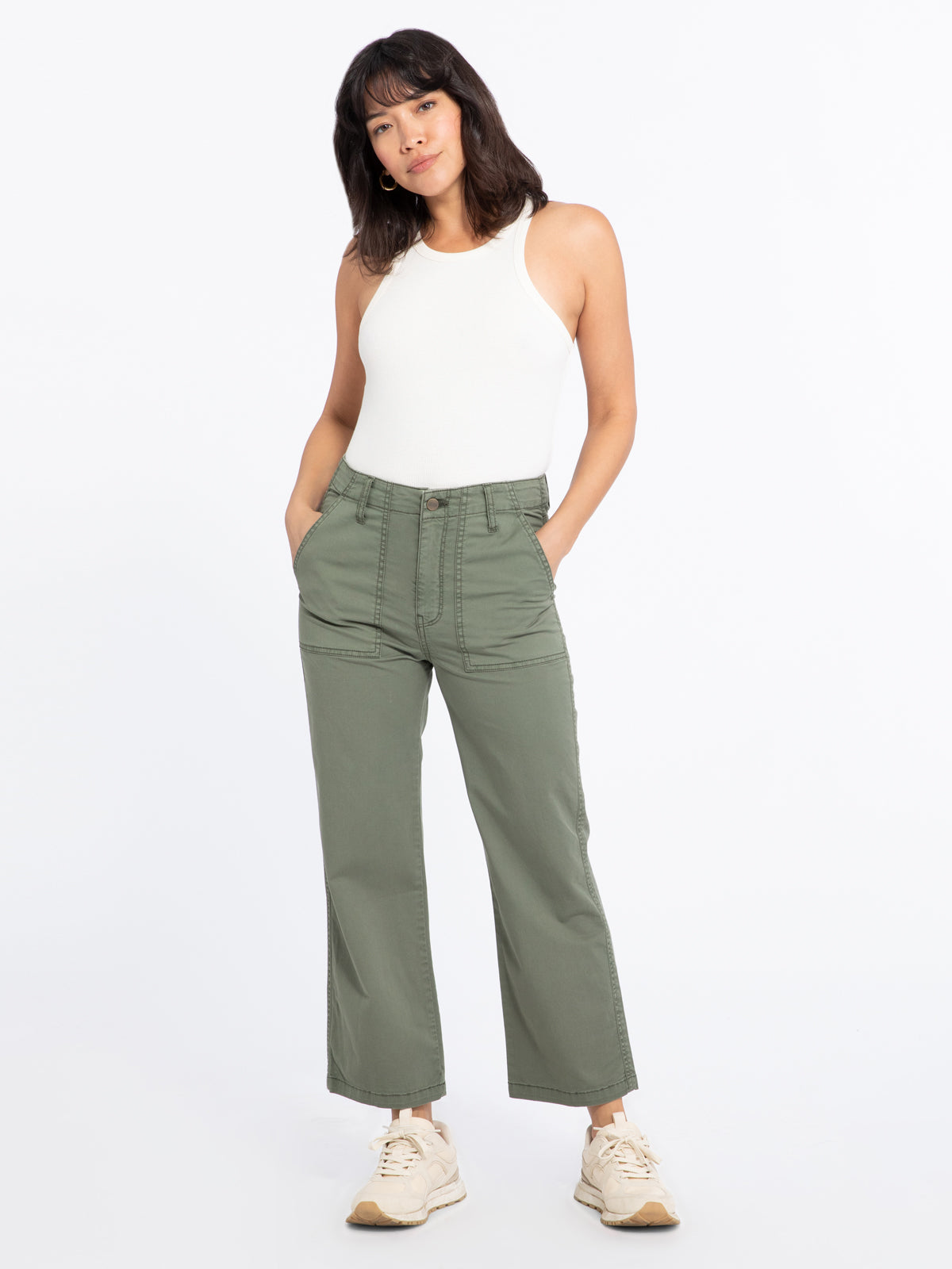 Model wearing green Vacation Crop Hiker Green pants from Sanctuary with white tank top and cream running shoes (7351187734736)