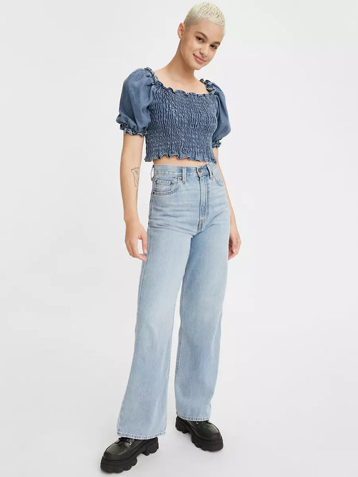 Women is wearing Levi's high loose Jeans. Jeans feature five pockets, high waist and relaxed fit for a vintage-inspire look. Jeans are styled with a dark denim top and black massive loafers. (7721840804048)