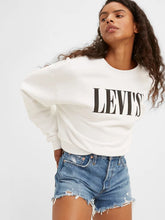 Load image into Gallery viewer, woman is wearing Levi&#39;s 501 original high rise shorts. These denim shorts feature high waist, vintage-inspired fit and chewed hem. Denim shorts are paired with a white Levi&#39;s sweatshirt. The photo demonstrates a closer look at the shorts (7721829892304)
