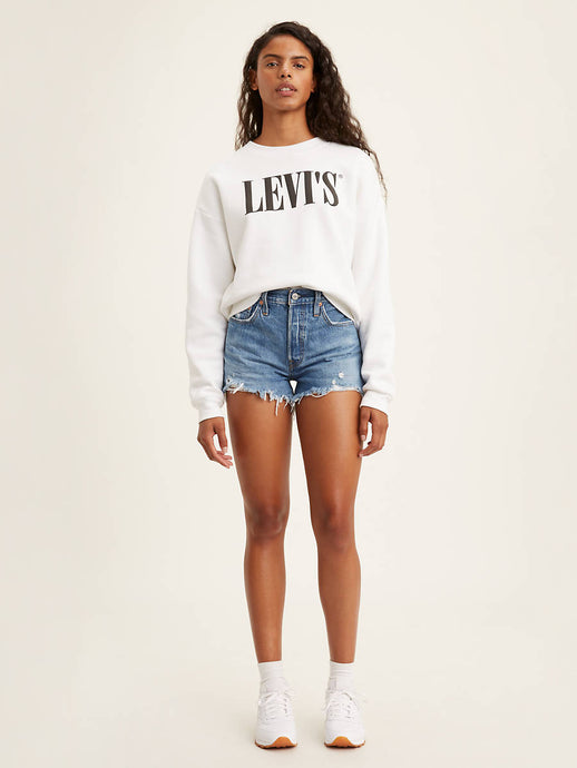 woman is wearing Levi's 501 original high rise shorts. These denim shorts feature high waist, vintage-inspired fit and chewed hem. Denim shorts are paired with a white Levi's sweatshirt and white sneakers. (7721829892304)