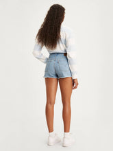 Load image into Gallery viewer, women is Levi&#39;s original high rise shorts. Light blue jean shorts feature chewed hem and vintage inspired fit. The photo demonstrates jean shorts from the back (7721852829904)
