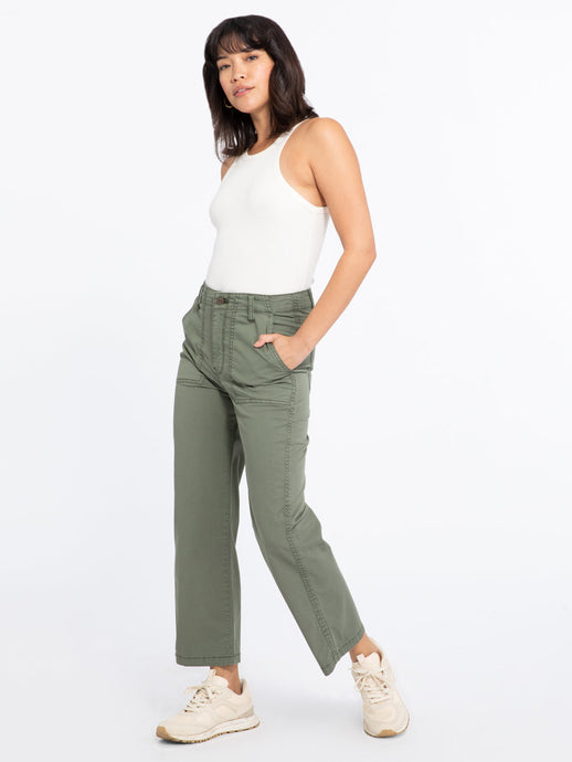 Model wearing green Vacation Crop Hiker Green pants from Sanctuary with white tank top and cream running shoes (7351187734736)