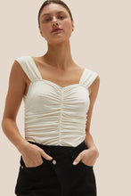Load image into Gallery viewer, the model is wearing crescent arosa gathered sleeveless top. the top is ivory color, features all-over gathering detail with thick shoulder straps in a fit-to-bodice silhouette.  (7756403507408)
