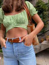 Load image into Gallery viewer, Model wearing green floral tie back floral print crop top from Lush with Cello jeans and genuine brown leather belts from Most Wanted USA and Trimmed see-through handbag. (7707222147280)
