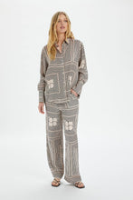 Load image into Gallery viewer, This photo contains a Kimaya shirt from Soaked in Luxury which has horizontal and vertical stripes forming squares with double half circles in the middle in black and beige colors. (7700578599120)
